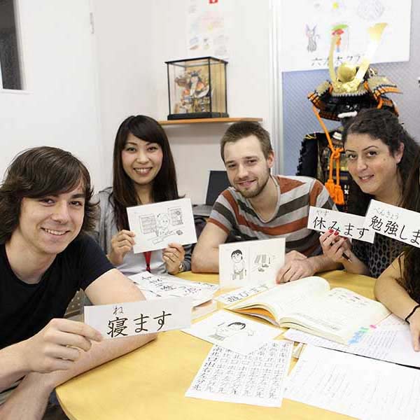 International students and Japanese teacher holding kanji flashcards