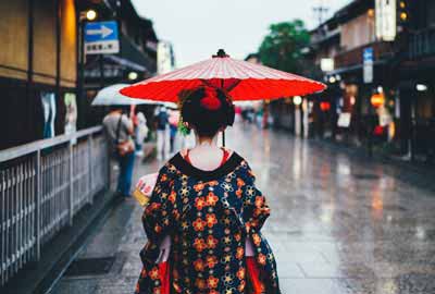 Maiko wearing a kimono in Kyoto holding an umbrella