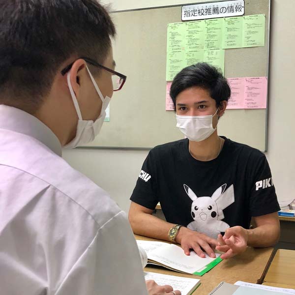 Japanese staff meeting with international student at a desk