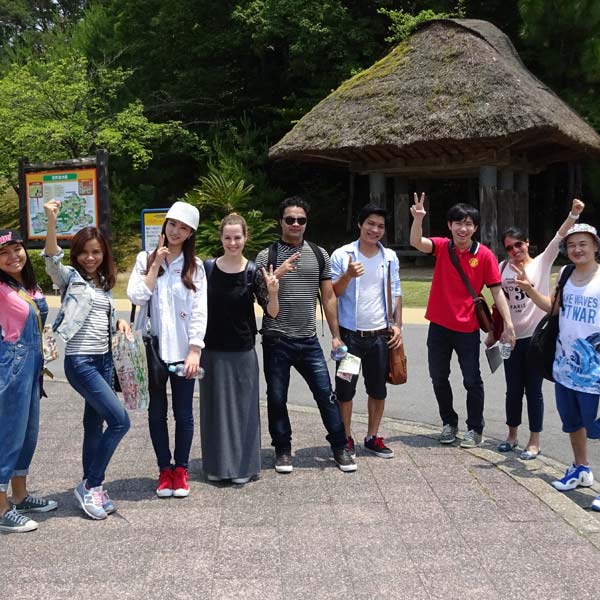 International students in Japan posing in front of a hut