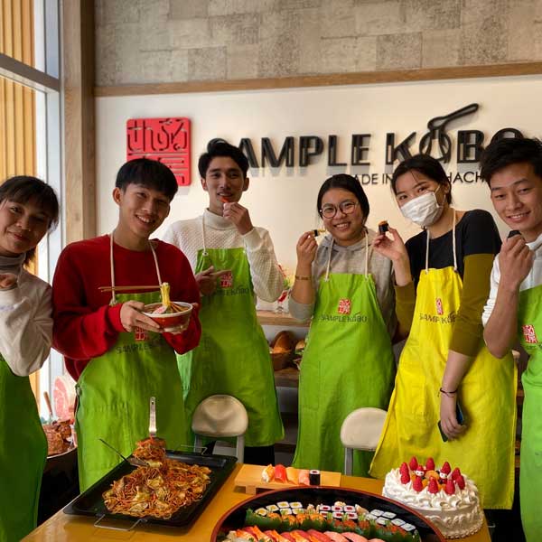 International students wearing an apron cooking Japanese food