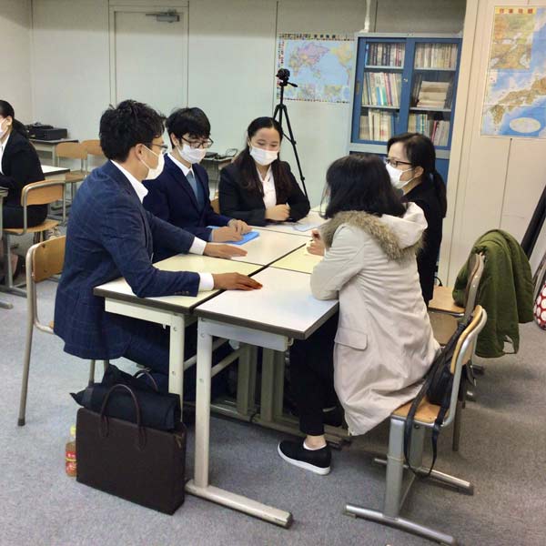 International students and Japanese staff sitting in circles at a desk